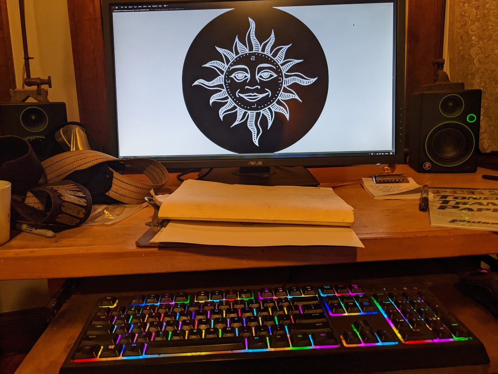 a computer screen showing a design for a headbadge &mdash; a sleepy faced sun with serpentine rays and cardinal points labeled S C U L